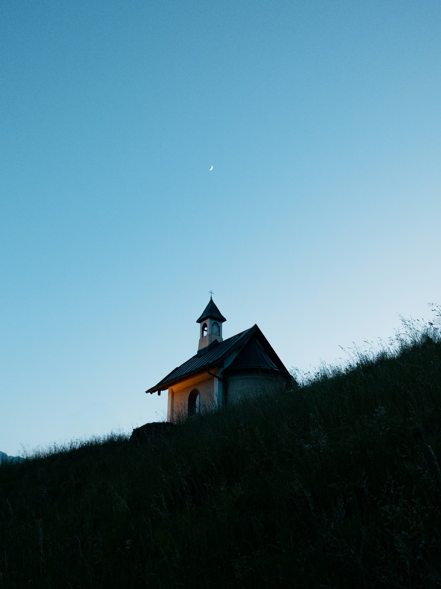 A small chapel on a hillside at blue hour